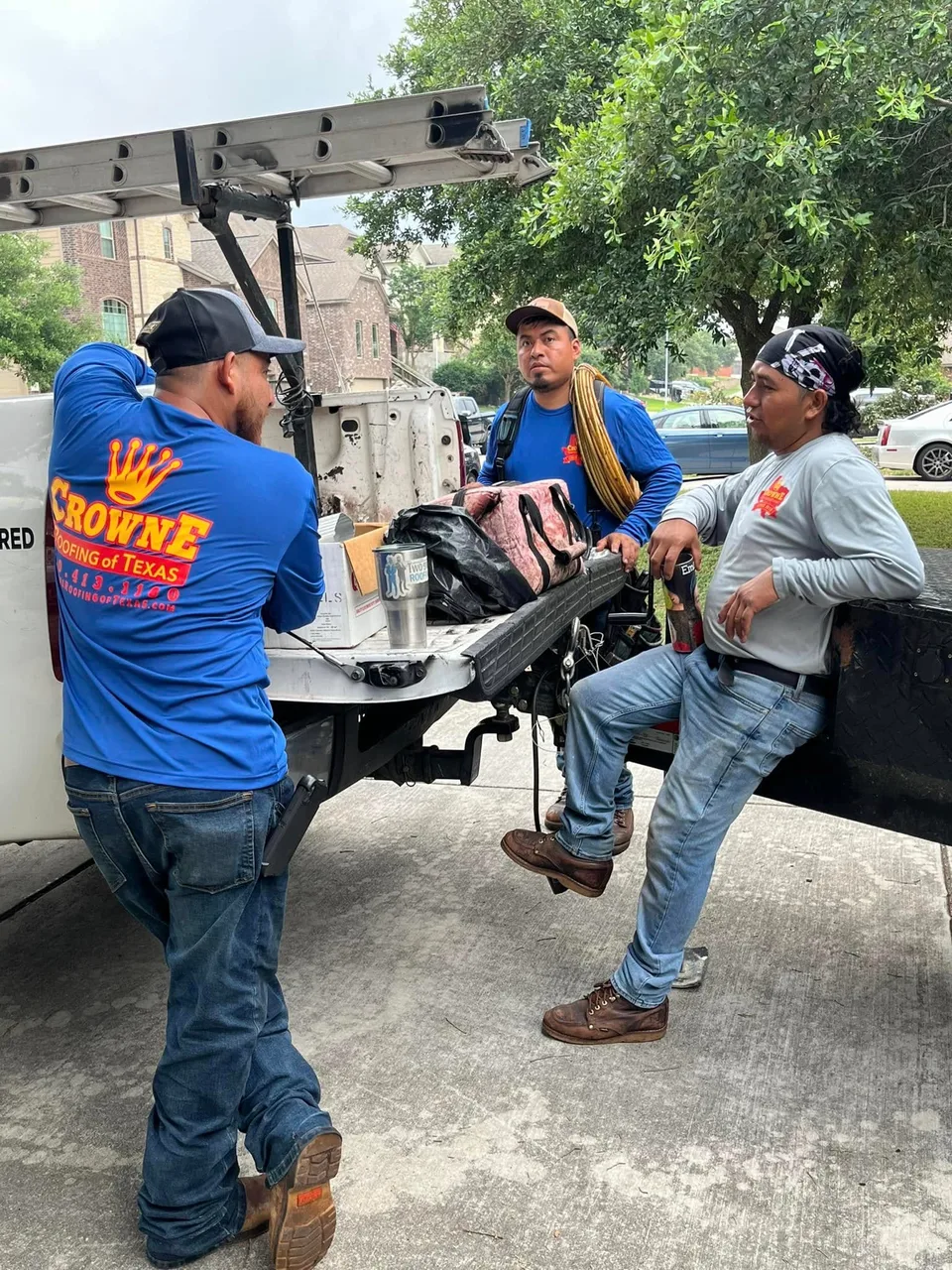 Crowne Roofing crew members beside a work truck