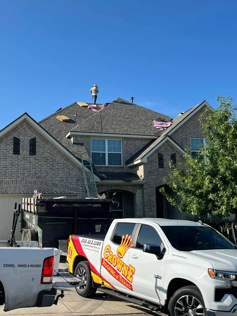 Crowne Roofing trucks at a residential roofing job site